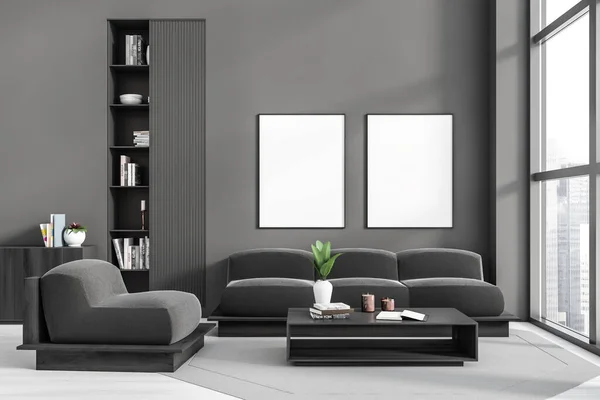 Dark living room interior with sofa and soft armchair, shelf with books and coffee table. Panoramic window on city skyscrapers, carpet on hardwood floor. Two mockup canvas posters , 3D rendering