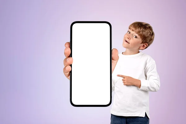 男の子の笑顔 指のコピースペース画面 ライラックの背景をモックアップする大規模なスマートフォンを指している ソーシャルメディアとネットワークの概念 — ストック写真