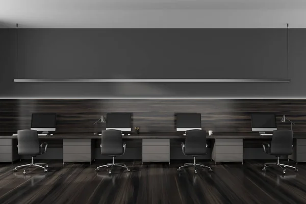 Dark coworking interior with pc desktop on table and armchairs on hardwood floor. Stylish workplace with tools and pc computers. 3D rendering