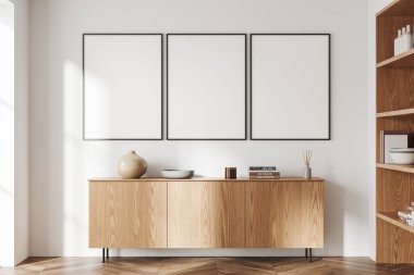 Beyaz oturma odasının içi ahşap büfe ve sanat dekorasyonuyla dolu. Sıcak İskandinav tasarımı ve ahşap döşeme. Sıraya dizilmiş üç tane tuval posteri. 3B görüntüleme