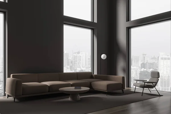 グレーの壁 暗い木製の床 長い茶色のソファと円形のコーヒーテーブルと背の高い窓の近くに立ってアームチェアと現代的なミニマリストのリビングルームのコーナー 3Dレンダリング — ストック写真