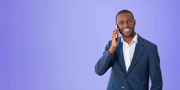 スマートフォンで話している黒人ビジネスマンの笑顔 コピースペースの紫色の背景に幸せな肖像画 モバイル会議 ネットワークの概念 — ストック写真