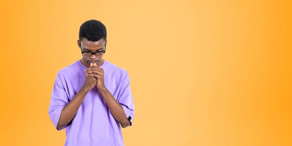 カジュアルな服や眼鏡で若いアフリカの男性大学生の肖像画は オレンジの背景の上に立ってハード考える 計画とキャリアの選択の概念 スペースのコピー — ストック写真