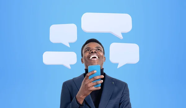 Elinde Telefonla Gülen Afrikalı Işadamı Mavi Arka Planda Mesaj Baloncukları — Stok fotoğraf
