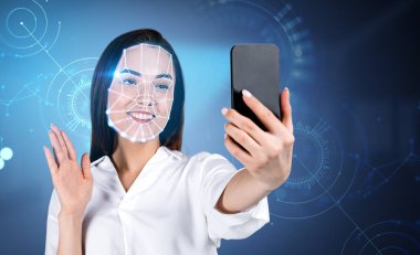 Resmi kıyafet giyen çekici bir iş kadını akıllı telefondan selfie çekiyor. Hologramı hat bağlantısı ile daire içine al. Yüz tanıma kavramı, biyometrik tarama, mobil açma