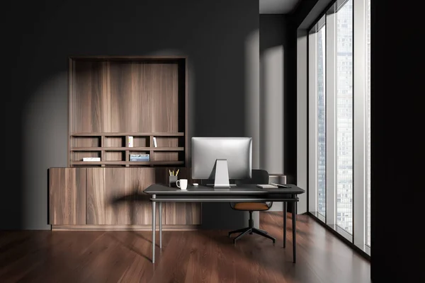 Dark office interior with work zone, desk with pc computer and shelf with decoration, hardwood floor. Panoramic window on skyscrapers. 3D rendering