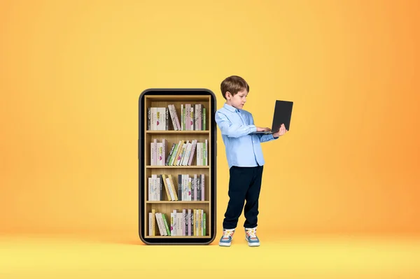 Bambino Ragazzo Che Utilizza Laptop Digitazione Schermo Smartphone Con Libreria — Foto Stock