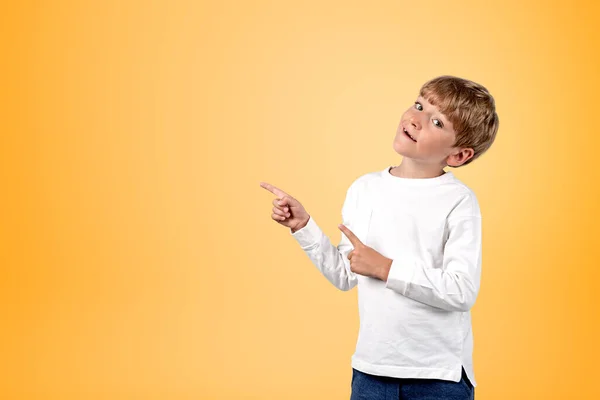 Çocuk Kameraya Bakıyor Parmakları Sarı Arkaplanı Işaret Ediyor Teklif Sunum — Stok fotoğraf