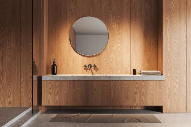 Lavabosu ve yuvarlak aynası olan rahat bir banyo güvertesi, güvertede havlusu olan aksesuarlar, gri beton zemin. Minimalist banyo alanı olan çağdaş bir daire. 3B görüntüleme