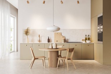 Beyaz duvarları, taş zemini ve lavabo ve fırının içinde sandalyeli yuvarlak yemek masasının yanında duran rahat bej dolapları olan modern mutfağın içi. 3d oluşturma