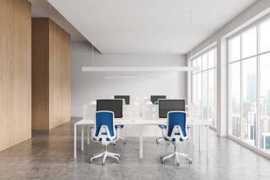 Beyaz ve ahşap duvarları, beton zemini, mavi sandalyeli ve şehir manzaralı büyük pencereli bilgisayar masaları olan şık bir açık uzay ofisi. 3d oluşturma
