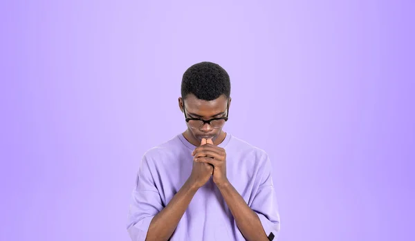 紫の背景の上に立つハード思考カジュアルな服や眼鏡で若いアフリカの男性大学生の肖像画 ブレインストーミングとキャリア選択の概念 — ストック写真