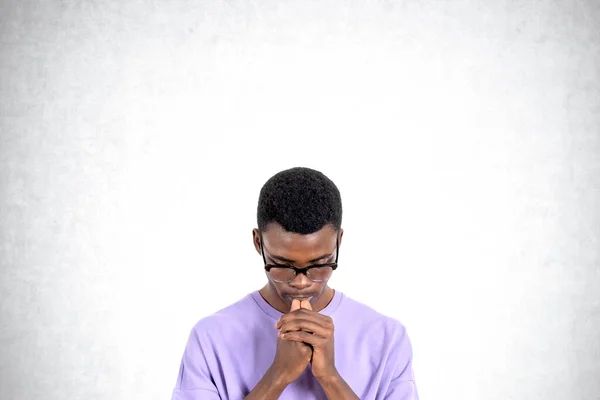 カジュアルな服や眼鏡を身に着けている若いアフリカの男性大学生の肖像画は 具体的な背景に立って考えている 問題解決とキャリア選択の概念 — ストック写真