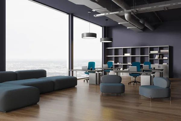 stock image Interior of modern open space office with dark blue walls, wooden floor, computer tables with blue chairs and comfortable gray couch and armchairs in lounge area. 3d rendering