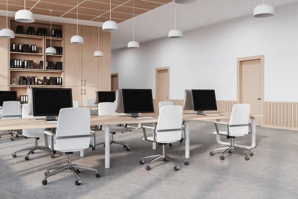 Corner of modern open space office with white and wooden walls, concrete floor, comfortable computer tables with white chairs, bookcase and row of doors in the wall. 3d rendering