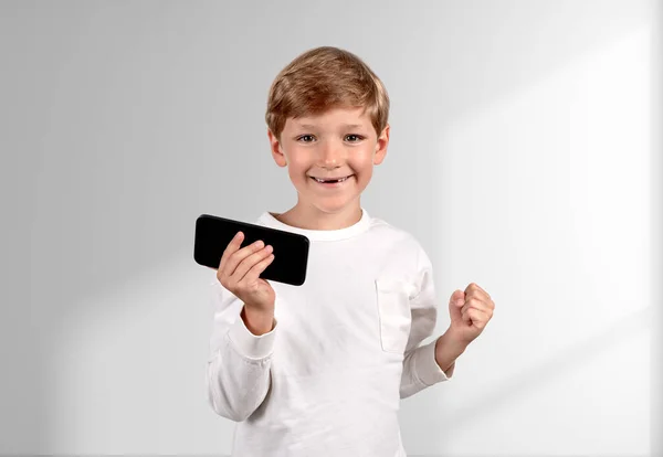 Heyecanlı Çocuk Portresi Elinde Telefon Yumruğuyla Boş Beyaz Arka Planı — Stok fotoğraf