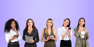 Beş gülümseyen iş kadını birlikte çalışıyor. Fotokopi uzayının mor arka planında portreler var. İletişim ve ağ için dijital cihazlar kullanılıyor. Çevrimiçi bağlantı kavramı