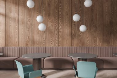 Koyu ahşap duvarları, ahşap zemini, rahat kahverengi koltukları ve mavi sandalyeli yuvarlak gri masaları olan şık bir kafe. 3d oluşturma