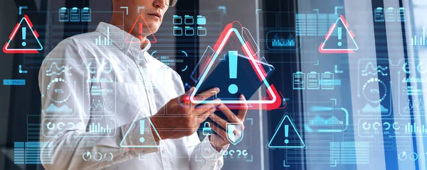 stock image Businessman using tablet in hands, side view. Warning system alert sign hologram and glowing digital security and business infographics, icons and dashboard. Concept of virus and cyber attack