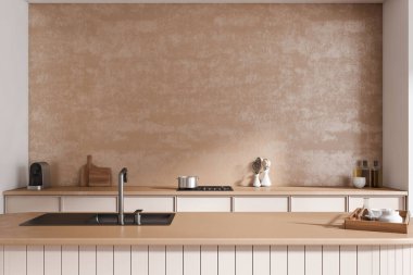 Bar adası ve lavaboyla dolu sıcak bir mutfak. Mutfak malzemeleri, kaşık ve yağ şişesi, tepside taş tabaklar. Boş bej beton duvar. 3B görüntüleme