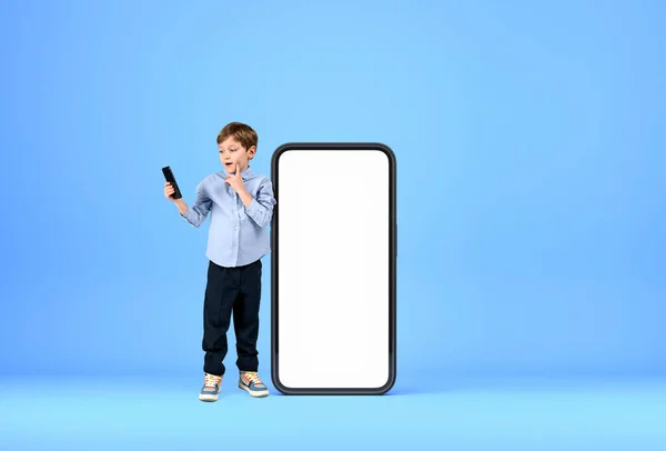 Elinde Cihaz Olan Dalgın Bir Çocuk Büyük Akıllı Telefonun Yanında — Stok fotoğraf