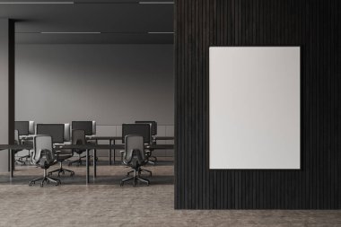 Karanlık çalışma odasının içinde ortak masa ve bilgisayar monitörleri, koltuklar, gri beton zemin. Bölümde tuval posteri olan bir iş yeri. 3B görüntüleme