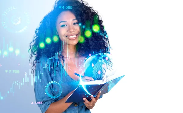 Smiling black businesswoman take note, double exposure colorful forex analysis hologram, stock market candlesticks with earth globe. Concept of business education. Copy space