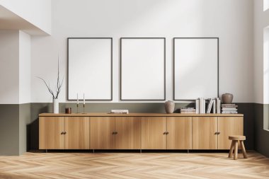 Parlak oturma odasının içini üç boş beyaz poster, şifonyer, dolap, çanak çömlek, kitap, mum, beyaz duvar, vazo, ahşap zemin. Minimalist tasarım kavramı. Model yap. 3d oluşturma