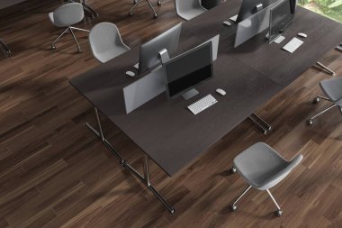 Ahşap zemin ve gri sandalyeli siyah ahşap bilgisayar masaları olan şık bir açık uzay ofisi manzarası. Teknoloji ve iletişim. 3d oluşturma