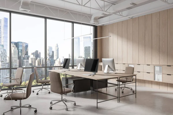 Modern workplace interior with pc desktop on table, armchairs on light concrete floor. Corner view of coworking space with wooden shelf drawers, panoramic window on New York skyscrapers. 3D rendering