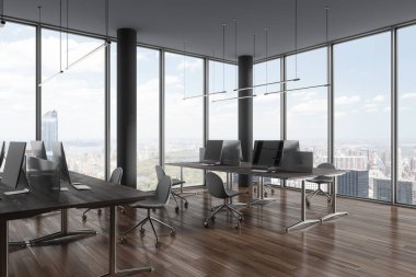 Gri sütunları, ahşap zemini, panoramik pencereleri şehir manzarası olan ve sırayla gri sandalyeli bilgisayar masaları olan şık bir açık uzay ofisinin köşesi. 3d oluşturma