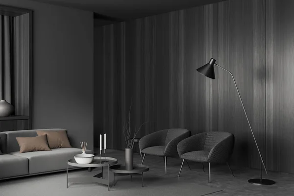 Corner view on dark living room interior with sofa, armchairs, coffee table with crockery, grey wall, concrete floor, vase. Concept of minimalist design. 3d rendering
