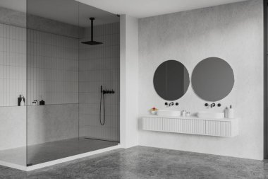 Modern banyonun köşesinde beyaz ve fayanslı duvarlar, beton zemin, rahat beyaz çift lavabo iki yuvarlak ayna ve cam duvarlı duş kabini. 3d oluşturma