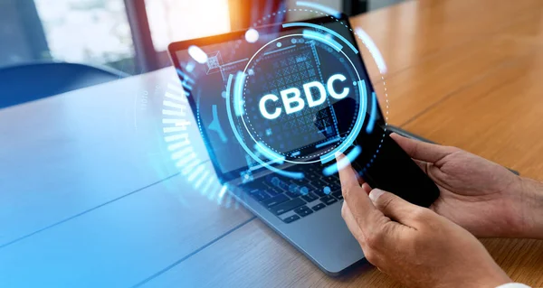 stock image Hands of businessman using smartphone and laptop at blurry office table with double exposure of CBDC interface. Concept of Central bank digital currency and fintech. Online banking