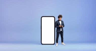 Orta Doğulu işadamı, uzun boylu, büyük bir akıllı telefon ekranının yanında mesaj atıyor. Web sitesi kavramı, çevrimiçi sohbet, sosyal medya ve internet iletişimi