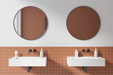 Beyaz ve turuncu kaplamalı modern banyo ve üzerinde iki yuvarlak ayna olan rahat beyaz çift lavabo. 3d oluşturma