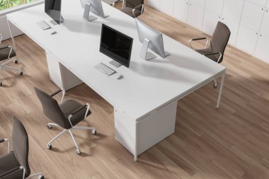 Paylaşılan masada, parke zeminde bilgisayar masaüstüyle samimi bir iç çalışma manzarası. Minimalist mobilyaları, dolapları ve teknolojisi olan şık bir iş köşesi. 3B görüntüleme