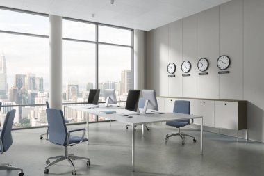 Beyaz duvarları, beton zemini olan modern açık uzay ofisinin köşesinde mavi sandalyeli ve saati gösteren beyaz bilgisayar masaları var. 3d oluşturma