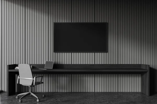 黑暗的家庭办公室内部与扶手椅和黑色木制桌子与计算机 电视屏幕上的灰色墙壁 现代公寓中的最低限度工作空间 3D渲染 — 图库照片