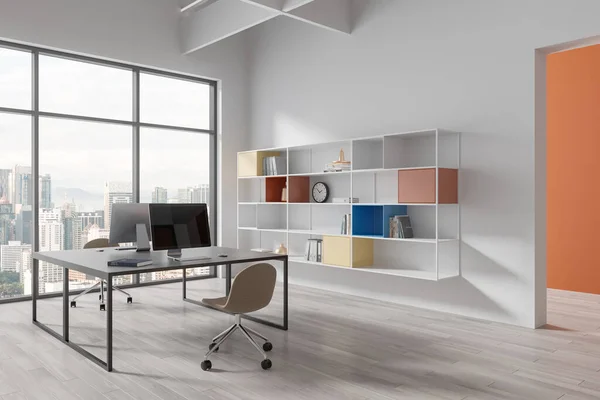 White office interior with pc computers on a shared table, side view shelf with colorful decoration. Modern work corner with panoramic window on Kuala Lumpur skyscrapers. 3D rendering