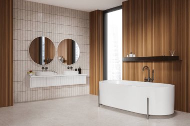 Modern banyonun köşesinde ahşap ve beyaz fayanslı duvarlar, fayanslı zemin, rahat beyaz küvet ve üzerinde iki yuvarlak ayna olan beyaz tezgahta duran çift lavabo. 3d oluşturma