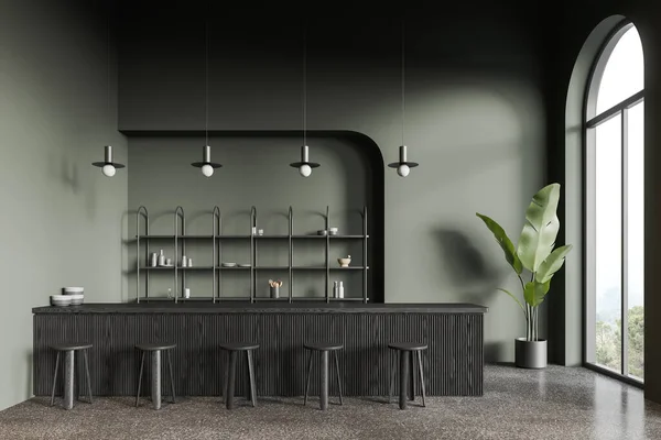 Interior of stylish coffee shop with dark green walls, concrete floor, comfortable dark wooden bar counter with stools and arched windows. 3d rendering