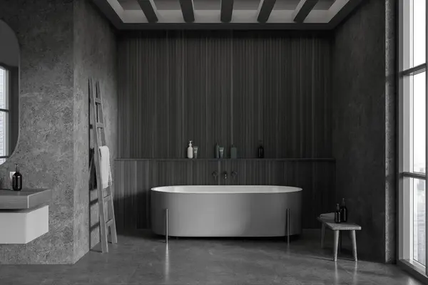 Dark home bathroom interior with bathtub and sink, grey concrete tile floor. Bathing room with shelf, accessories and panoramic window on skyscrapers. 3D rendering