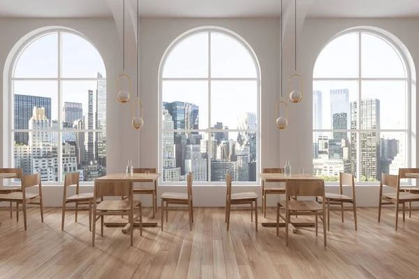 Interior of modern restaurant with white walls, wooden floor, comfortable square wooden tables with chairs and arched windows with city panorama. 3d rendering