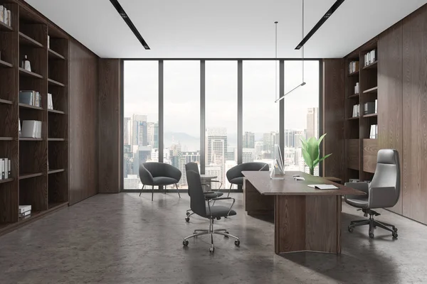 Interior of stylish CEO office with wooden walls, concrete floor, comfortable computer table, bookcase and cozy gray armchairs for visitors standing near panoramic window. 3d rendering