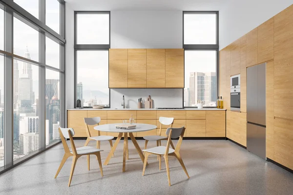White home kitchen interior with eating table and cabinet, kitchenware and oven with refrigerator mounted. Panoramic window on Kuala Lumpur skyscrapers. 3D rendering