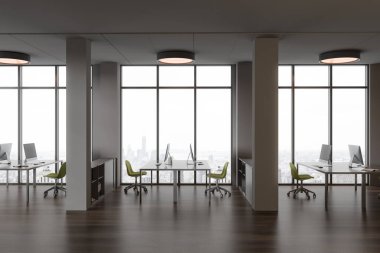 Gri duvarları, koyu ahşap zemini, yeşil sandalyeli bilgisayar masaları şehir manzarası ve sütunları olan büyük pencerelerin yanında duran şık açık uzay ofisinin içi. 3d oluşturma