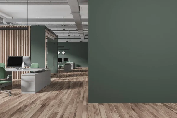 Interior of stylish open space office with green and wooden walls, wooden floor, massive gray computer desks with green chairs and mock up wall on the right. 3d rendering