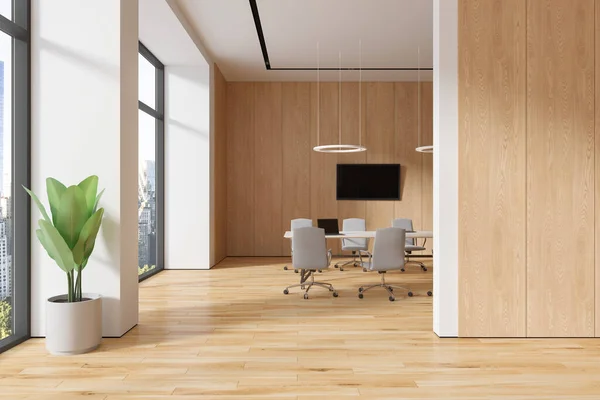Interior of modern office meeting room with white and wooden walls, wooden floor, long conference table with beige chairs and big TV set on the wall. 3d rendering