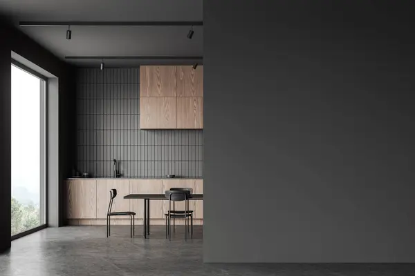 Dark home kitchen interior with dining table and seats, grey concrete floor. Wooden and tile eating and cooking space with cabinet and panoramic window. Mockup copy space wall partition. 3D rendering